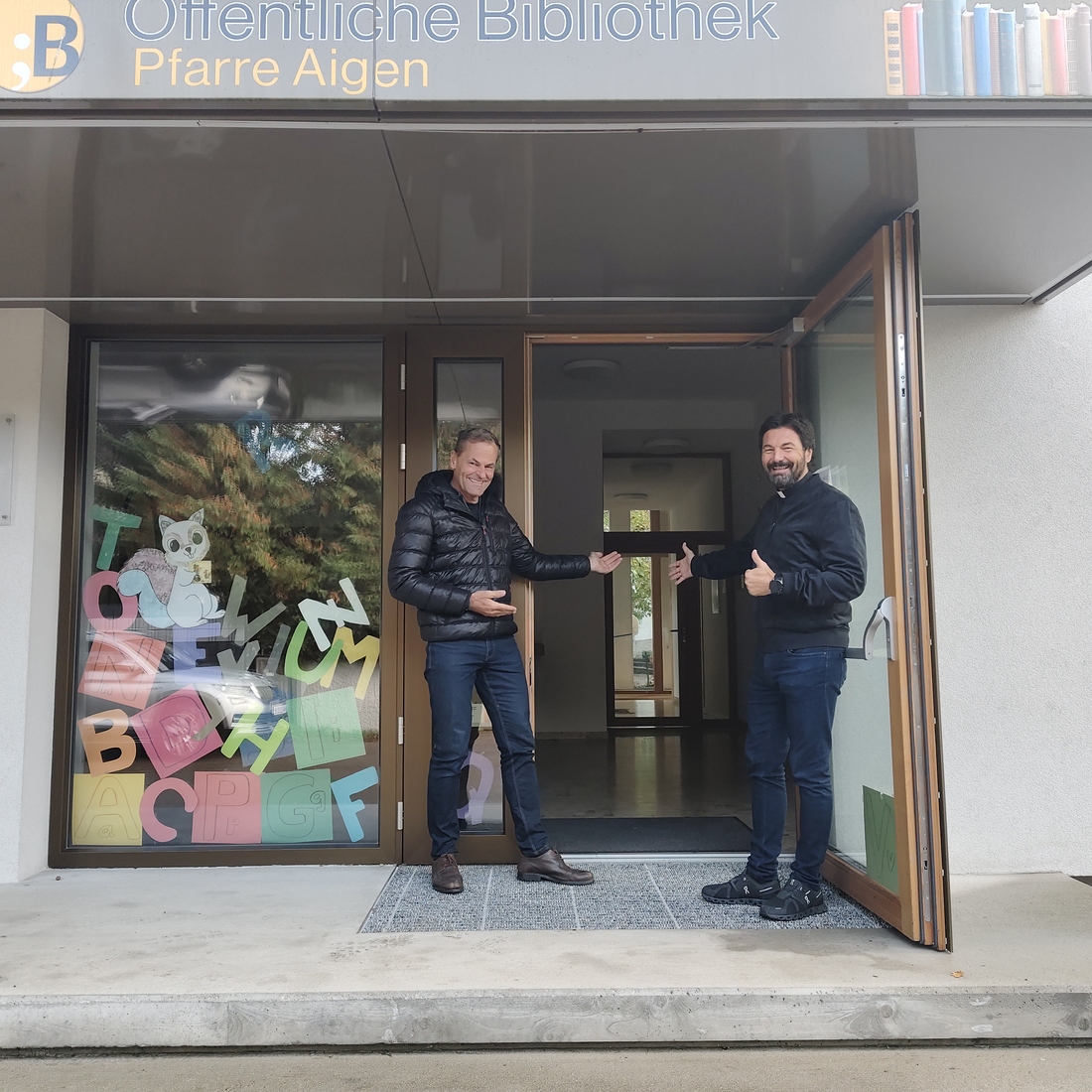 Am Eingang zum Pfarrzentrum in Salzburg-Aigen erwarten Diakon Dino Bachmaier und Robert Radauer (v.r.n.l) die Teilnehmerinnen