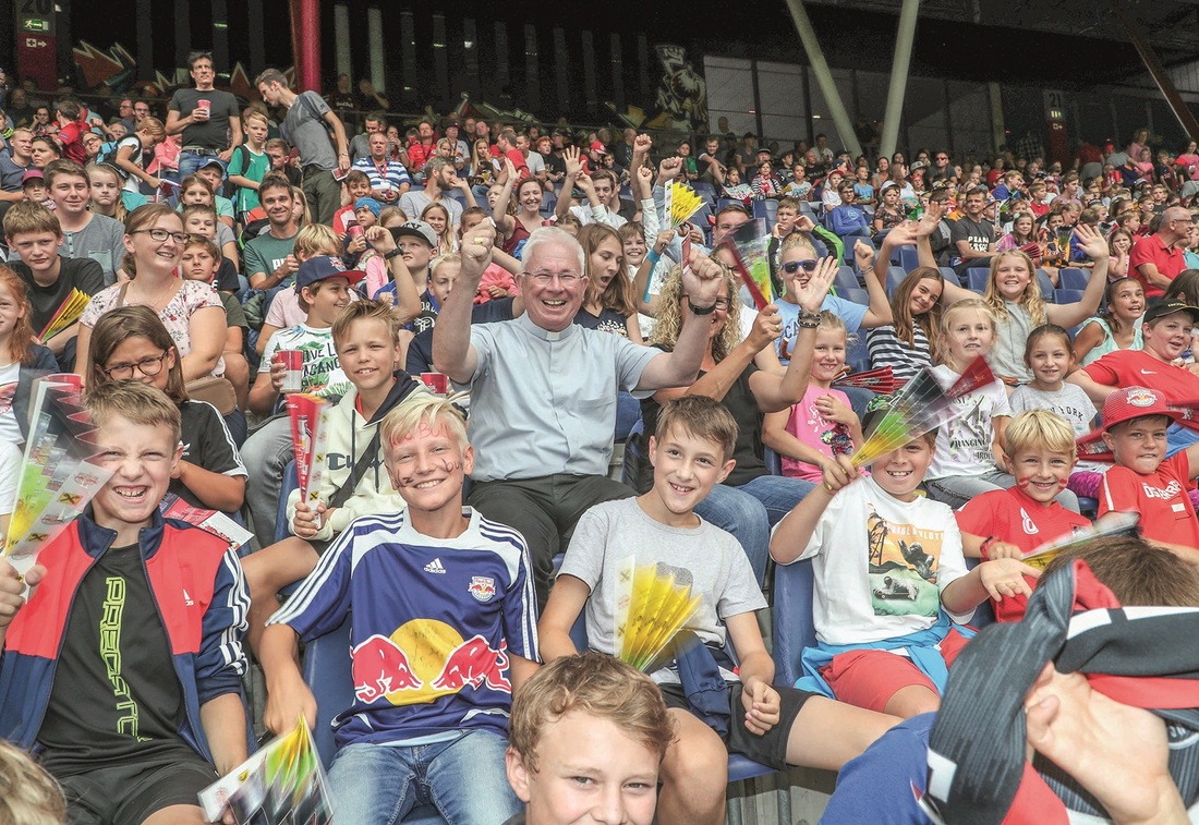 Erzbischof Franz Lackner mit Ministranten und Ministrantinnen im Salzburger Fußballstadion.