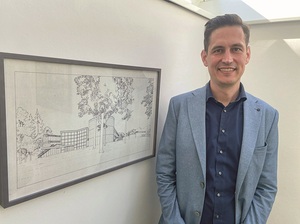 Der „Hausherr“ von St. Virgil: Direktor Jakob Reichenberger  neben einem grafischen Entwurf des Bildungszentrums.