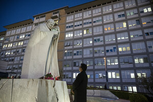 Ein Mann betet am Abend des 13. Oktober 2026 vor der Statue von Papst Johannes Paul II. am Gemelli-Krankenhaus in Rom (Italien)