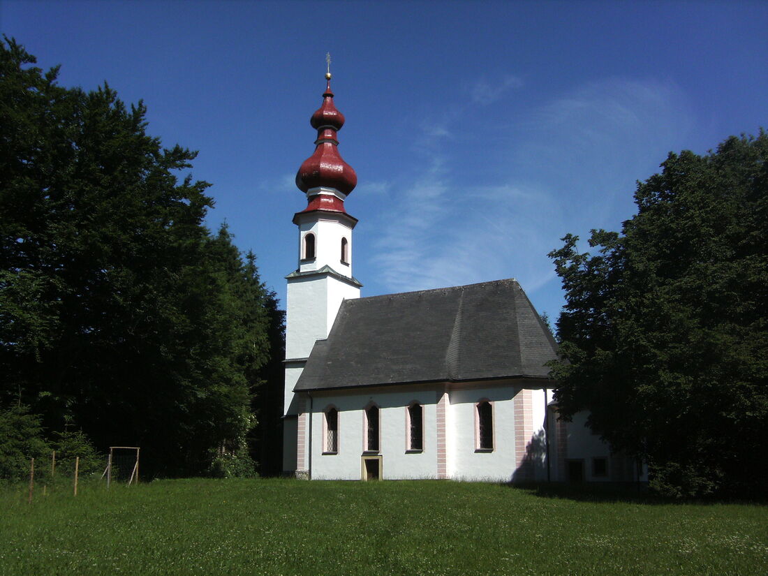 St. Johann am Berg bei Köstendorf:  Vom Tal aus ist nur der Turm von St. Johann zu sehen, nur von der Nähe zeigt sich die ganze Kirche.    