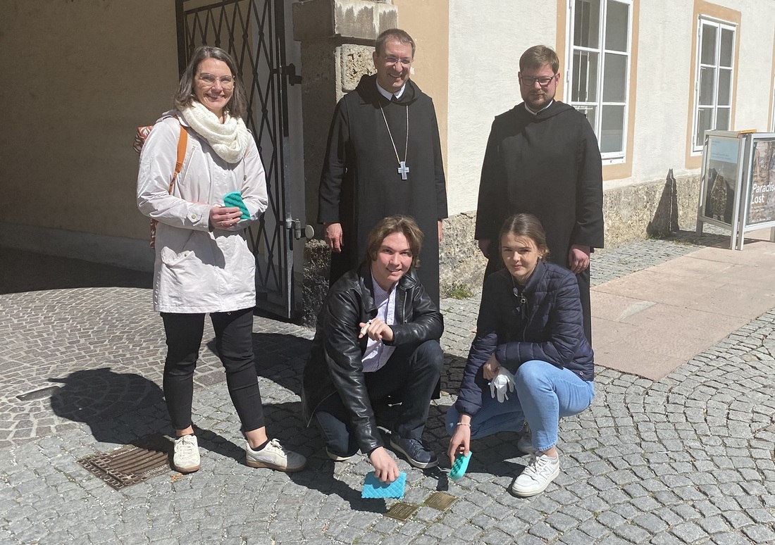 Mitglieder der Katholischen Jugend bei der Reinigung von Stolpersteinen im Innenhof von St. Peter mit Erzabt Korbinian Birnbacher und dem zukünftigen Erzabt Jakob Auer.  