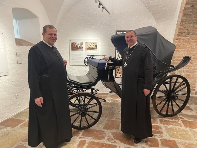 Pater Michael Eppenschwandtner und Abt Johannes Perkmann zeigen, wie die Benediktiner in früheren Zeiten reisten.
