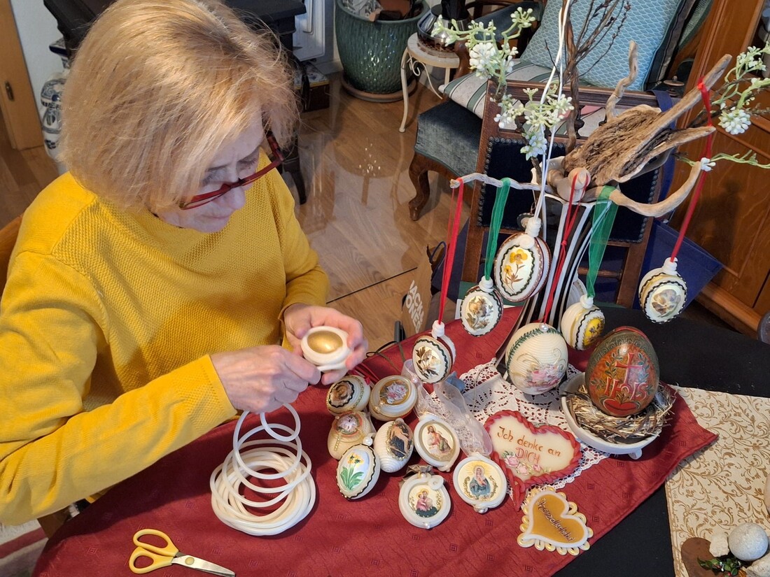 Die 'Wachswicklerin' lässt aus Wachsschnüren, Papierbildchen und verschiedenen Borten filigrane Kunstwerke mit religiösen Bezügen entstehen.