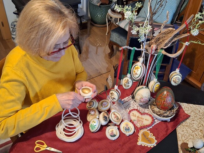 Die 'Wachswicklerin' lässt aus Wachsschnüren, Papierbildchen und verschiedenen Borten filigrane Kunstwerke mit religiösen Bezügen entstehen.