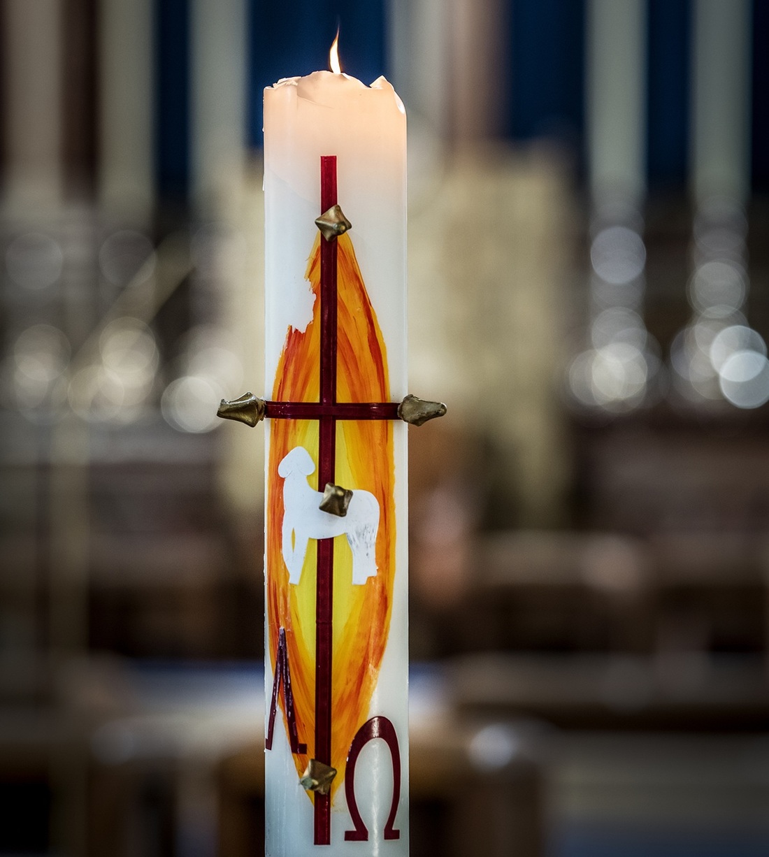 Die Osterkerze ist in der Regel weiß mit roter Schrift. Traditionelle Symbole sind das Kreuz sowie die Buchstaben Alpha und Omega.