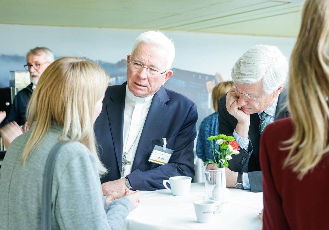 Erzbischof Franz Lackner im Gespräch mit einer Tagungsteilnehmerin.