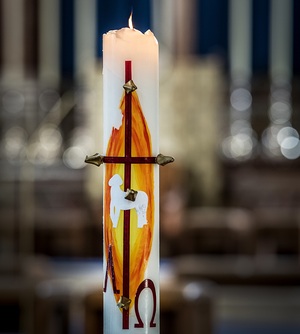 Die Osterkerze ist in der Regel weiß mit roter Schrift. Traditionelle Symbole sind das Kreuz sowie die Buchstaben Alpha und Omega.