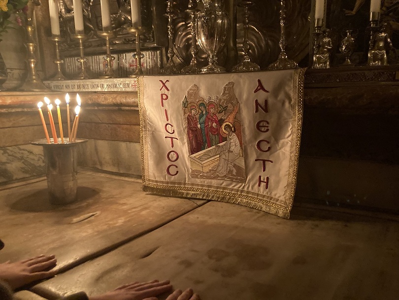 Ein ganz besonderer Augenblick am Heiligen Grab in Jerusalem: die Hände der Besucher ruhen auf dem Stein der Grabkammer, die als Ort der Auferstehung verehrt wird.